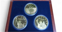 Three Liberty coins in wooden case