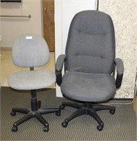 Two grey rolling office chairs - one with arms, on
