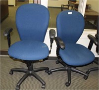 Two blue rolling office chairs