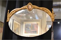 Oval mirror with carved gilt wood half frame