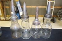 Three glass oil bottles and one jar with pour