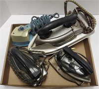 Group of vintage irons and iron trays.