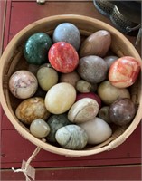 Basket of carved stone eggs, different colors,
