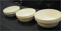 Three stoneware mixing bowls, one marked