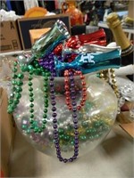 MARDI GRAS BEADS IN A LARGE GLASS VASE