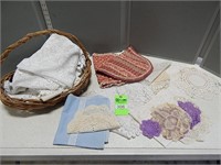 Basket with assorted doilies, tablecloths and othe
