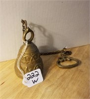 Bell on chain with design on it