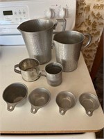 Contents of cabinet, old metal measuring cups,