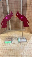 Pair of wooden red birds on poles