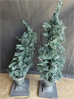 Artificial lighted Christmas tree in urns