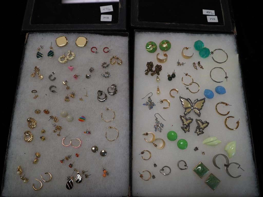 Two containers of earrings mostly pierced