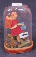 A pressed wax figurine of little girl hiking