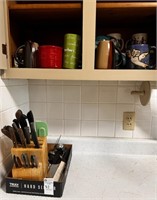 Contents of Kitchen Cabinet Including Mugs, Knife