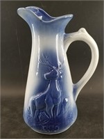 Blue and white umbra pitcher with a stag on the fr