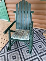Two green outdoor rockers, small table and rug
