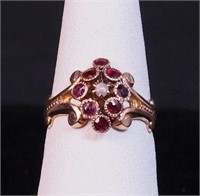 A 10K yellow gold ring with red stones and a seed