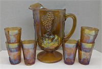 Orange carnival glass pitcher and glasses set.