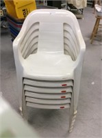 Six white plastic chairs
