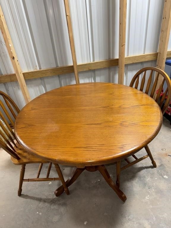Round wooden kitchen table with two chairs.