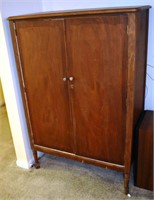 2 door wood cabinet, being used as a media center;