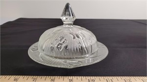 Dome-covered butter dish.
