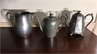 Three pieces of pewter, two teapots, one has a