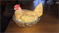 Ceramic chicken on a nest full of pens,