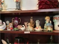 Top shelf of figurines, vases, and cats