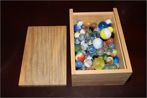 Wooden box containing various size marbles