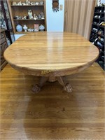 Oval oak dining room table with claw feet and 2-