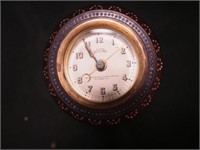 A round 3 1/2" diameter clock in wood case