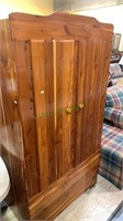 All cedar wood closet armoire with a top bar