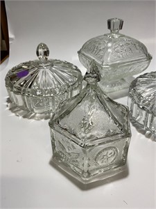 Four glass dishes, with lids & different patterns
