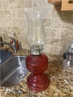 A oil lamp with a red base