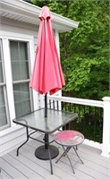 Square glass-top patio table with umbrella and sta