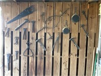 Primitive tools and pans having on wall
Please
