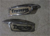 Pair of vintage Triumph motorcycle emblems.
