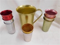 One anodized aluminum pitcher & 8 tumblers. Gold