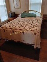 Gold tone headboard and full size mattress with a