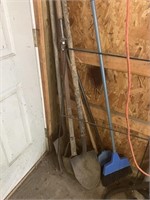 Shovel, post hole digger, brooms, etc in corner