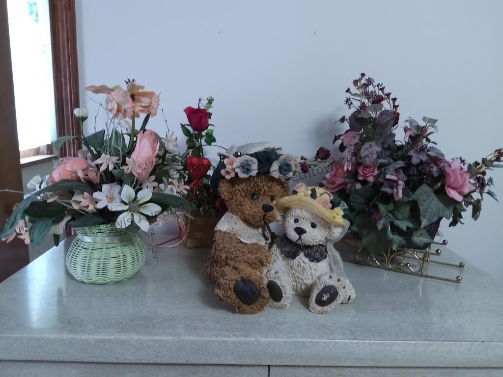 One bear figurine and three flower arrangements