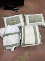Green comforter with pillows and sheet