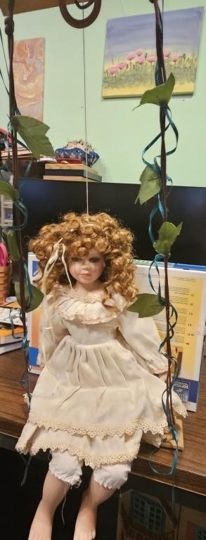 Porcelain doll on English ivy swing.  Marked