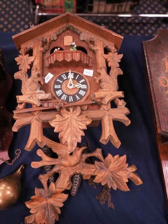 A cuckoo clock with carving of squirrels and