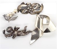 A group of silver brooches