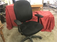 Black office chair. Armrests and castors.