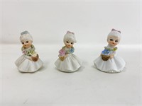 3 Small porcelain dolls with lei and flowers