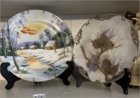 TWO decorative plates on stands. Winter scenes