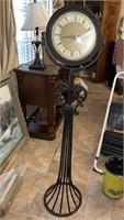 Clock w/wrought iron stand 54” T x 12” D.