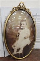 Curved bowed glass baby photo in ornate frame